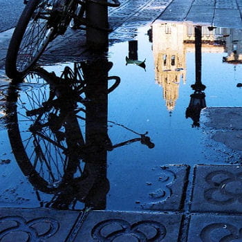 reflet de la ville sur une flaque d'eau dans une rue de barcelone.